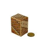 Japanese puzzle box shown with coin for size comparison.