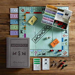 Game in play. Shown with stylish fabric-wrapped book, Vintage 1935 game board and cards, Deluxe removable bankers tray, Die-cast movers, Wood houses and hotels. Vintage Bookshelf Edition.