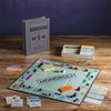 Game in play. Shown with stylish fabric-wrapped book, Vintage 1935 game board and cards, Deluxe removable bankers tray, Die-cast movers, Wood houses and hotels. Vintage Bookshelf Edition.